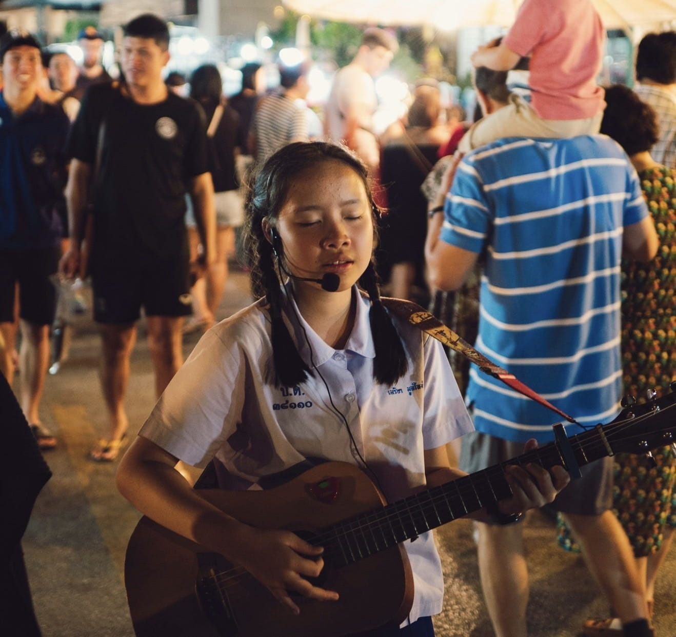 A girl is singing and playing a guitar